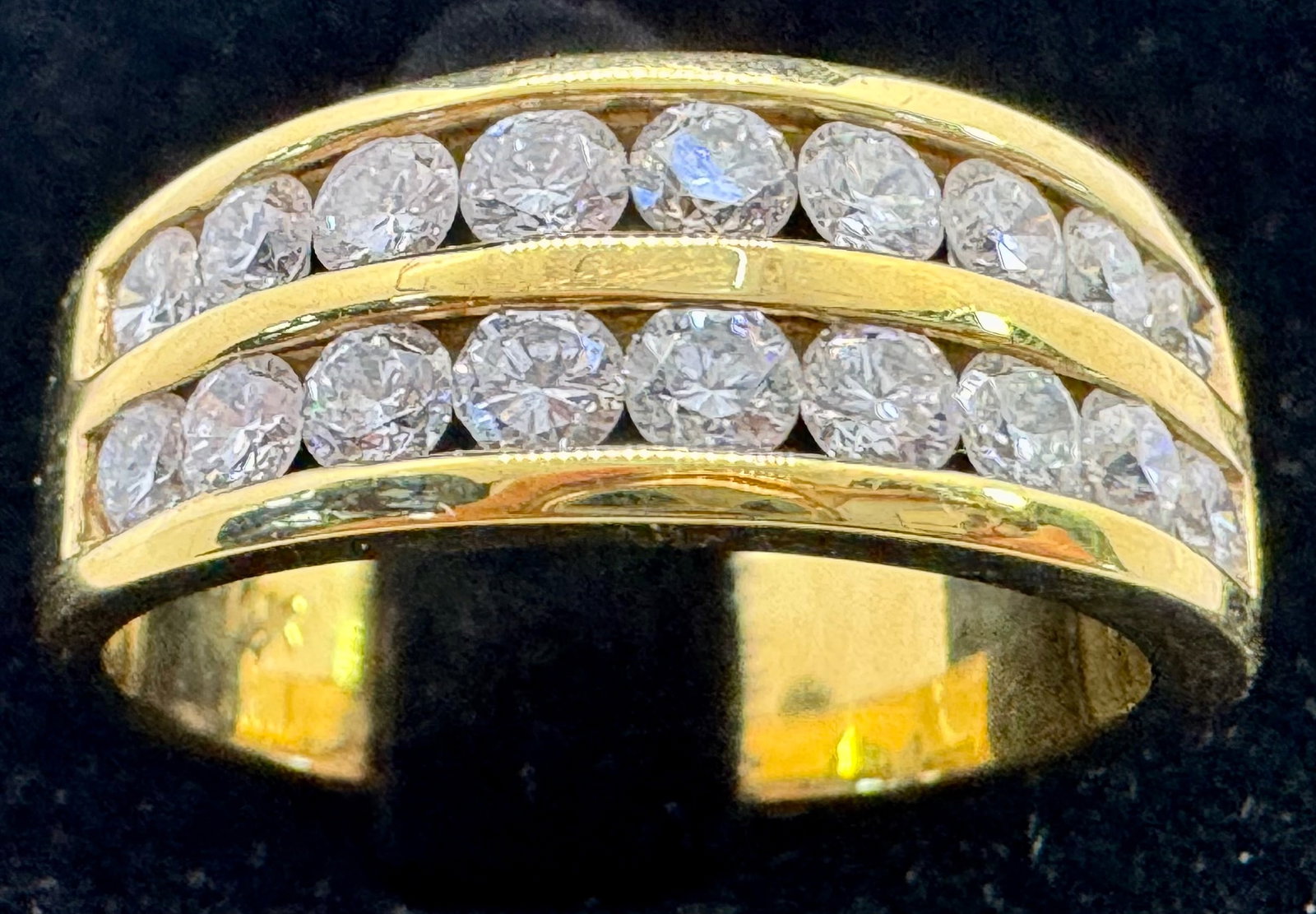 14K YELLOW GOLD 1.50CTW CHANNEL SET DIAMOND RING: This elegant 14K yellow gold diamond ring features 1.50 carats of round brilliant cut diamonds, expertly set in a seamless channel setting. The diamonds, boasting exceptional F-G color and VS2-SI1 cla