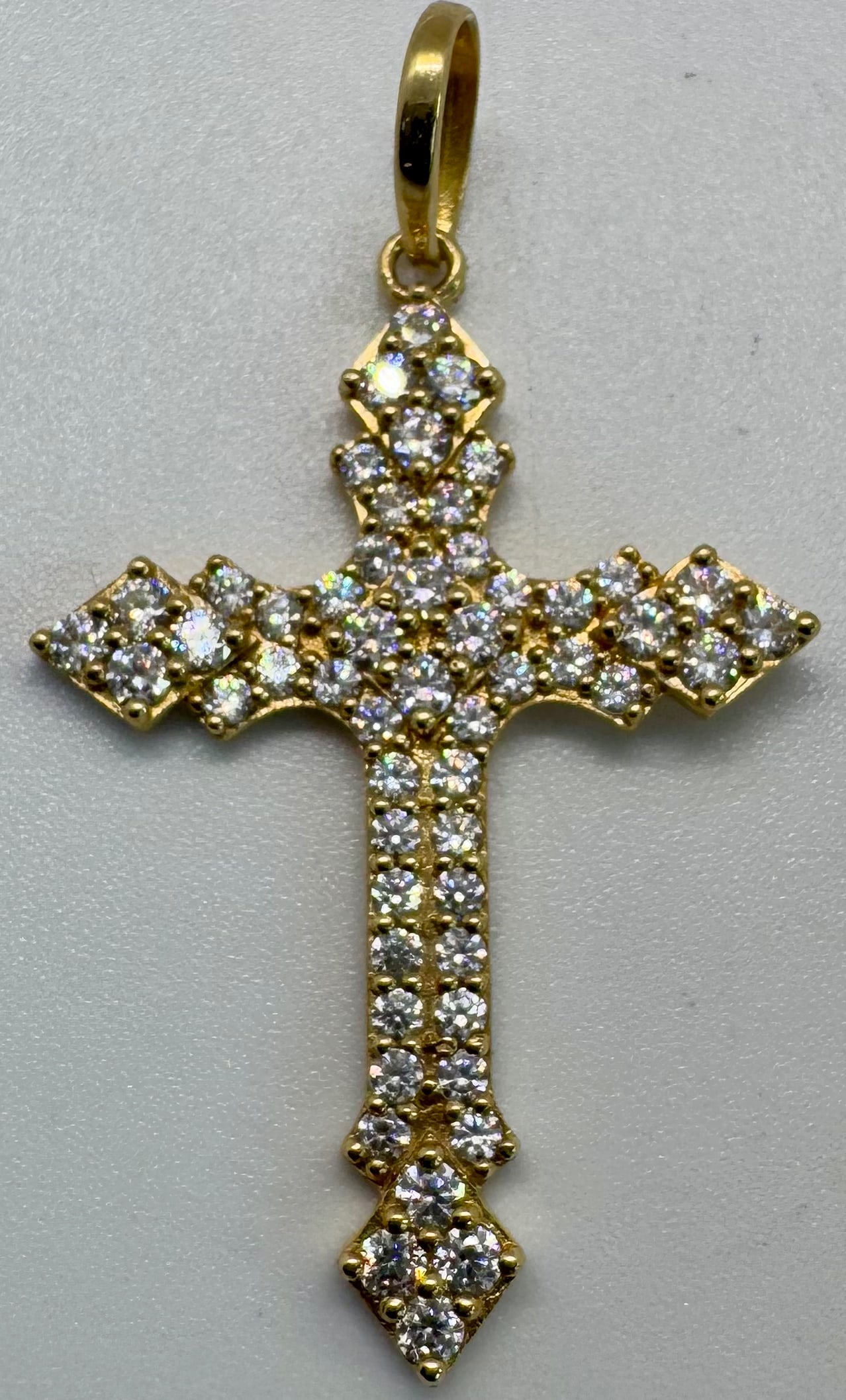 10K YELLOW GOLD & CUBIC ZIRCONIA CROSS PENDANT (2.1G): This stunning cross pendant is masterfully crafted in 10K yellow gold and adorned with brilliant cubic zirconia accents for a radiant, high-shine finish. Measuring 1.8 inches in length, this piece off