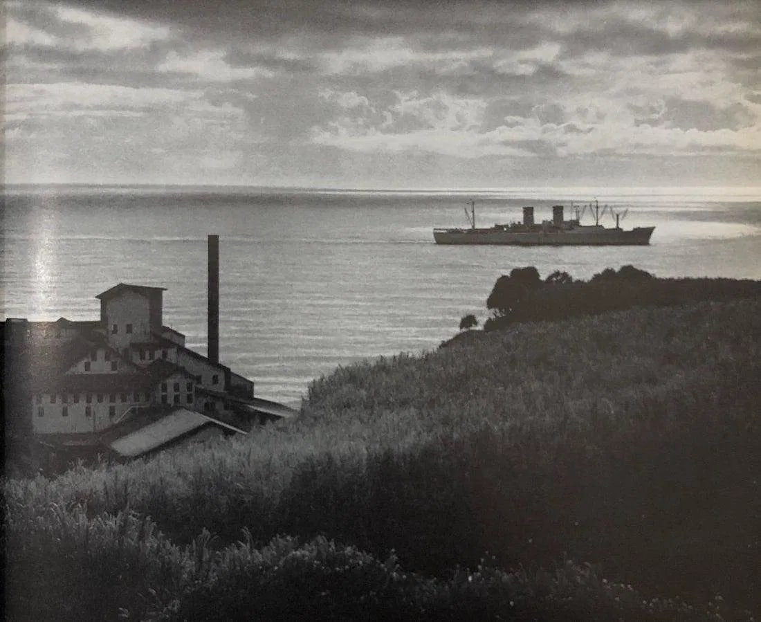ANSEL ADAMS (B. 1902-1984): Sugar mill and ship, Hilo Printed in colors mounted on archival board 7" x 8 1/2"