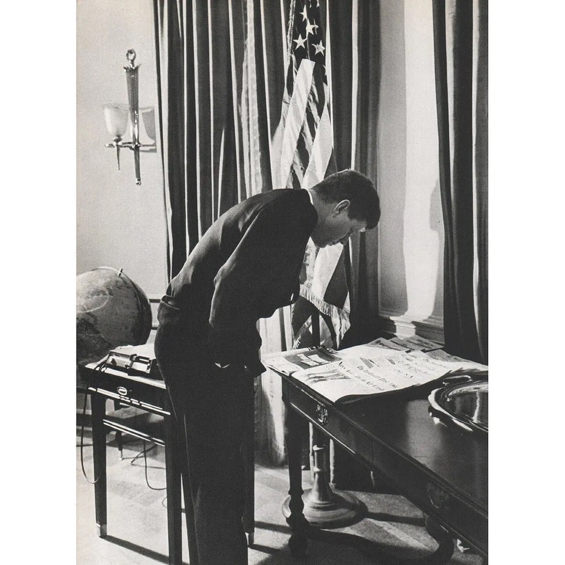 ALFRED EISENSTAEDT (AMERICAN) PRINT ON PAPER: Alfred Eisenstaedt (American) Print on paper. John F. Kennedy in his Office, reading daily newspapers. Printed in Switzerland in 1960s. 7.50 x 5.25 inches.
