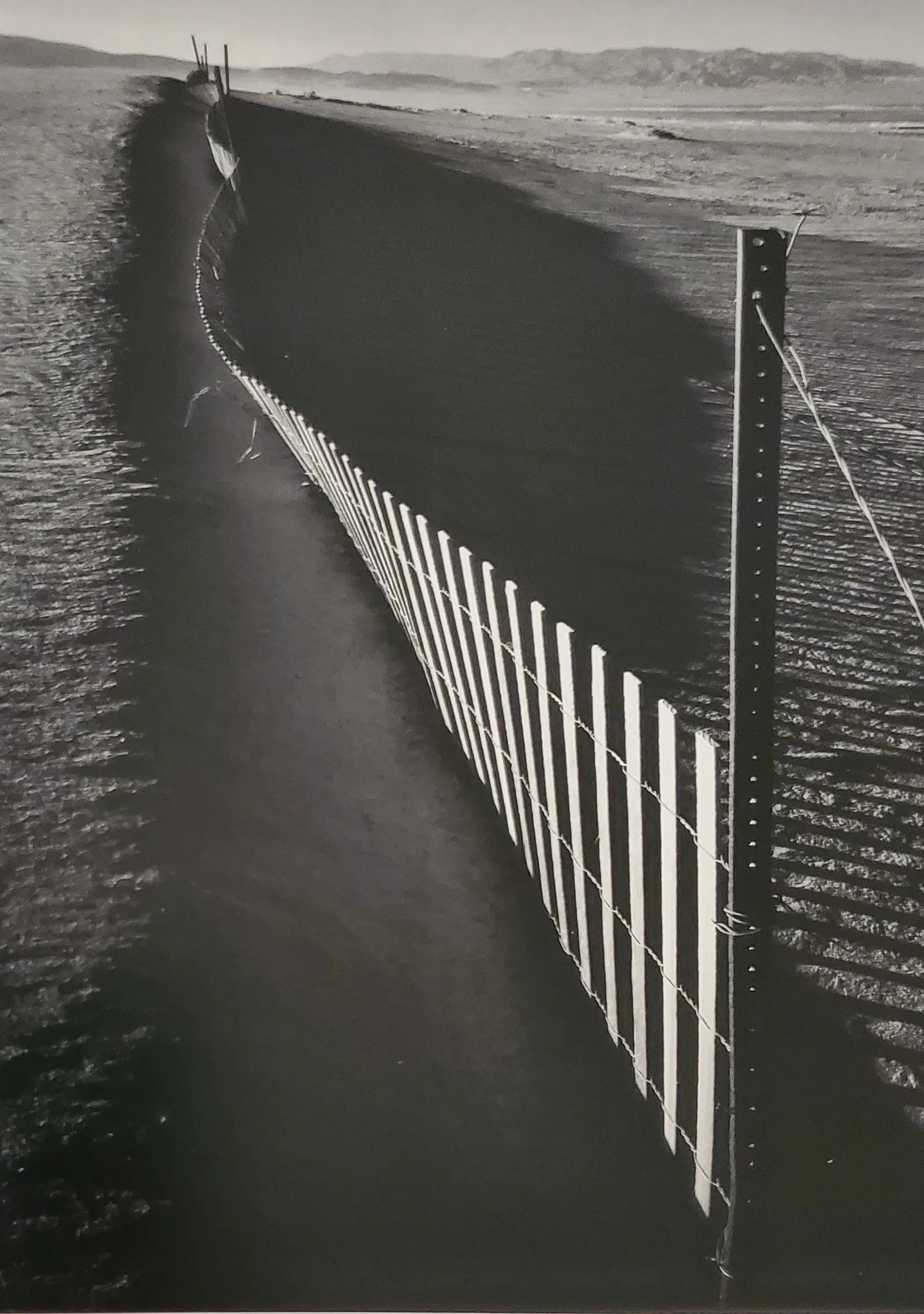 ANSEL ADAMS (AMERICAN) PRINT ON PAPER: Ansel Adams (American). Sand Fence, Near Keeler, California (1948). Printed in Italy in 2007 and Published by Little, Brown, and Company. Measures 4.00 x 6.00 inches. Semi-gloss.