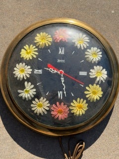 Vintage United Metal Goods Floral Wall Clock – Mid-Century Daisy Design – Brass Tone – 13": Charming vintage wall clock by United Metal Goods Mfg. Co., Brooklyn, NY, featuring a classic mid-century floral design. The face is decorated with raised daisy flowers in white and yellow (with a few