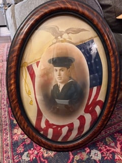 WWI Era US Navy Sailor Portrait Patriotic Flag Oval Frame Convex Glass: Early 20th century framed portrait of a US Navy sailor, presented in an oval format with convex glass and a patriotic background featuring an American flag and eagle motif.The sailor is shown in unifo