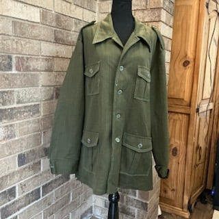 Vintage 1970s Olive Green Polyester Shirt Jacket Oversize: Vintage 1970s oversized shirt jacket in olive green polyester, featuring a classic wide pointed collar and button-front closure. Designed with two chest flap pockets and two lower flap pockets, giving