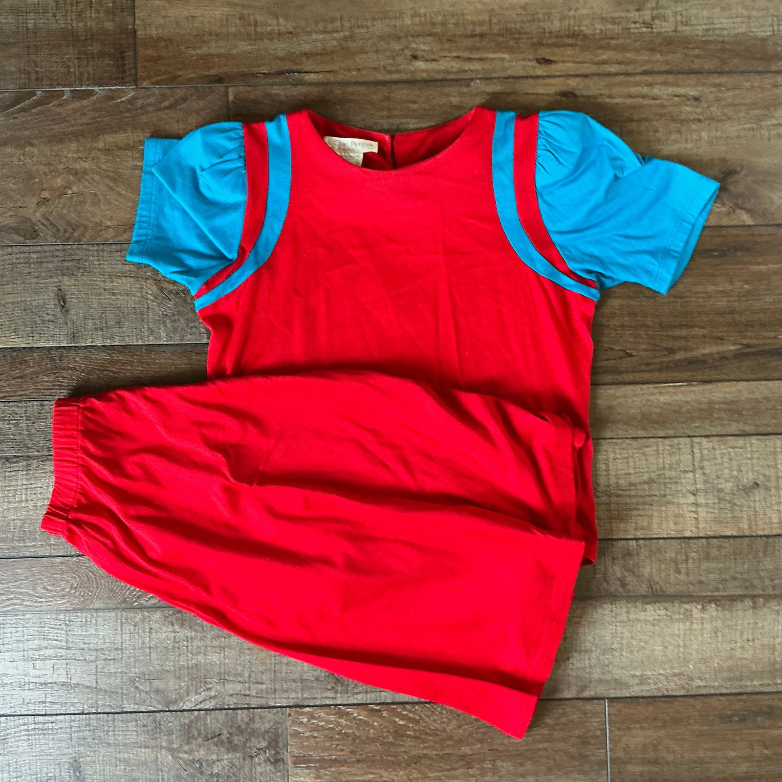 Vintage Red Knit Top with Blue Contrast Sleeves – Short Sleeve Retro Blouse Skirt Set: Vintage red knit top featuring eye-catching blue contrast sleeves and trim. This retro piece has a relaxed fit with softly gathered sleeve caps and a simple back keyhole closure.The bold color combina