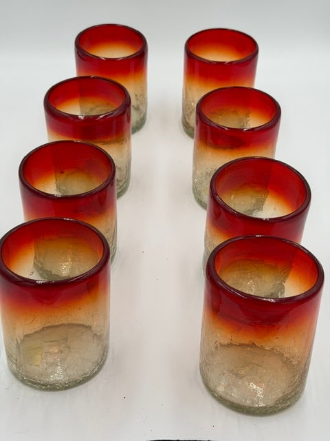 Set of 8 Mexican Hand-Blown Amberina Art Glass Tumblers: Beautiful set of eight hand-blown Mexican art glass tumblers featuring a vibrant amberina color transition from deep ruby red rims to warm amber and clear crackled bases. These striking glasses embody
