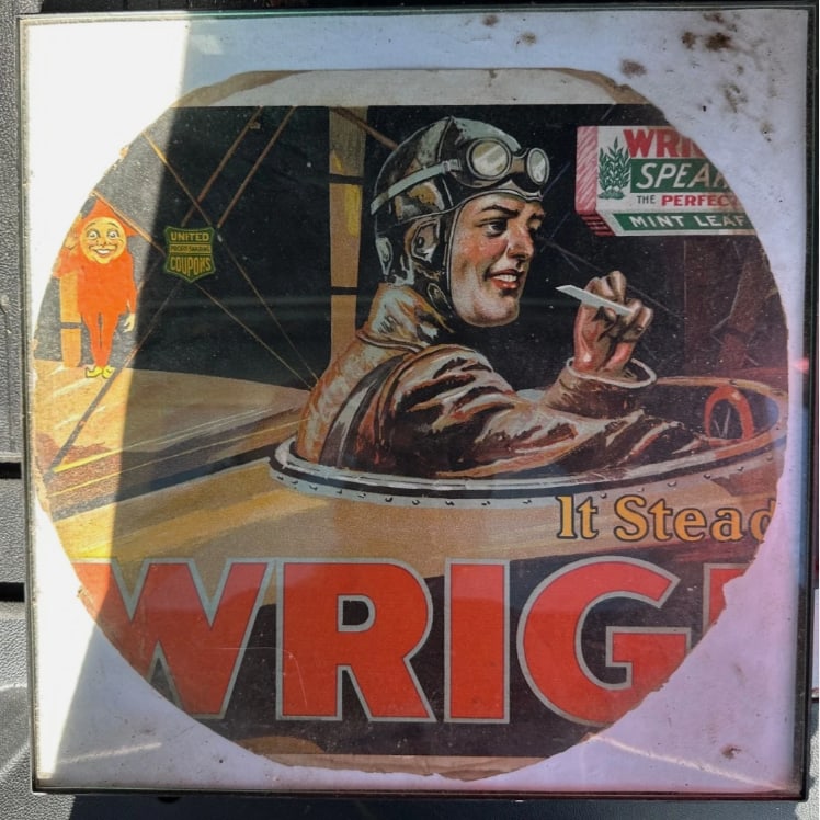 Rare WWI Era Wrigley’s Spearmint Gum Aviation Trolley Car Advertisement – Framed Antique Sign: Rare and visually striking World War I era Wrigley’s Spearmint Gum advertising display featuring an early aviator seated in an open cockpit airplane. Originally created for trolley or streetcar adve