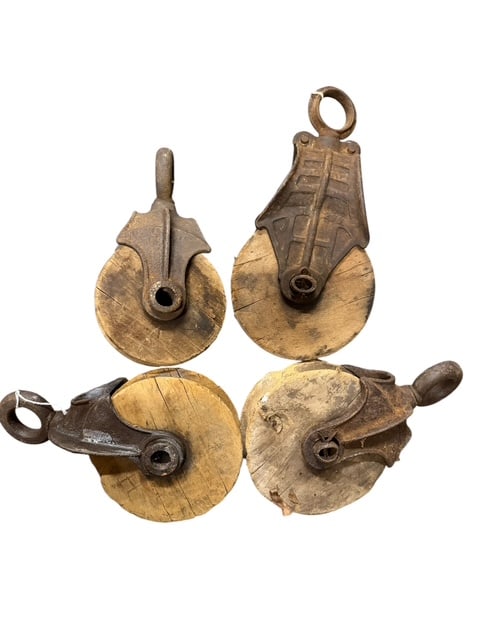 Collection of Four Antique Cast Iron & Wood Utility Pulleys 6": Group of four antique utility pulleys comprising cast iron housings with wooden pulley wheels, likely dating from the late 19th to early 20th century. Includes assorted forms and sizes, each retaining