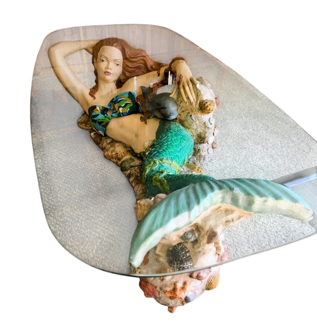 Large Mermaid Sculptural Glass Top Coffee Table: Large sculptural mermaid coffee table featuring an elaborate hand-painted mermaid with flowing red hair, detailed scales, and a shell-encrusted oceanic base supporting a custom freeform glass top. Thi