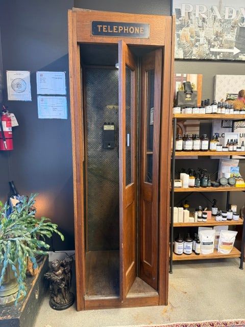 Antique Oak Telephone Booth with Original Interior, Payphone & Advertising Signs: Rare antique American oak telephone booth dating to the early 20th century. This handsome freestanding booth retains its original oak construction with glass-paneled door and side windows, embossed me