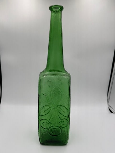 Vintage Made in Italy Green Empoli Art Glass Bottle with Embossed Cherry Design: Decorative vintage Made in Italy emerald green art glass bottle featuring a tall tapered neck, square-form body, and an embossed stylized cherry motif on both front and back. Produced in the Empoli tr