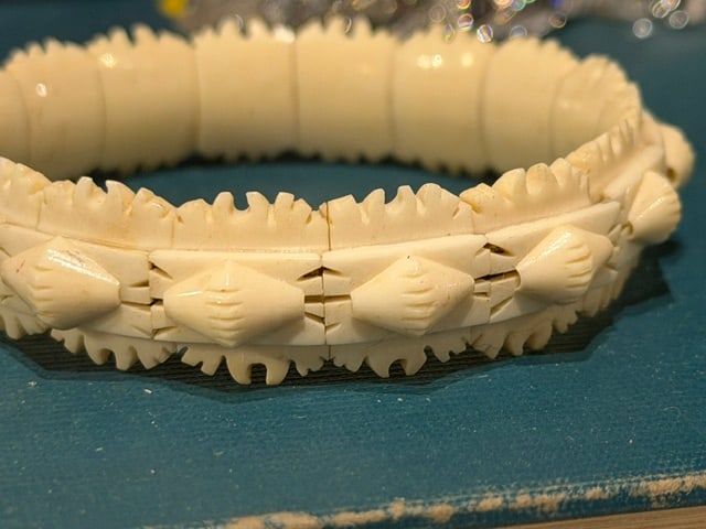 Vintage Hand-Carved Bone Link Bracelet with Geometric Design: Vintage hand-carved bone bracelet comprised of individually carved and articulated links featuring geometric diamond motifs and deeply notched decorative borders. The bracelet displays a warm cream-co