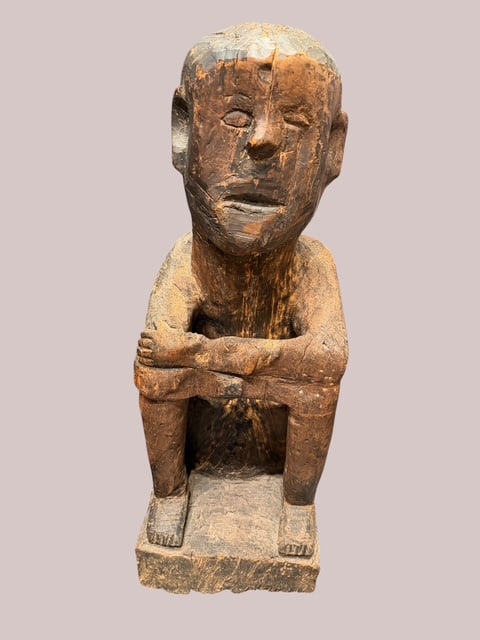 Large Tribal Hand-Carved Seated Wood Figure Sculpture, 35 In.: Large hand-carved wooden figure depicting a seated human form with arms folded across raised knees. Executed from a single block of hardwood, the sculpture features a stylized elongated head, simplifi