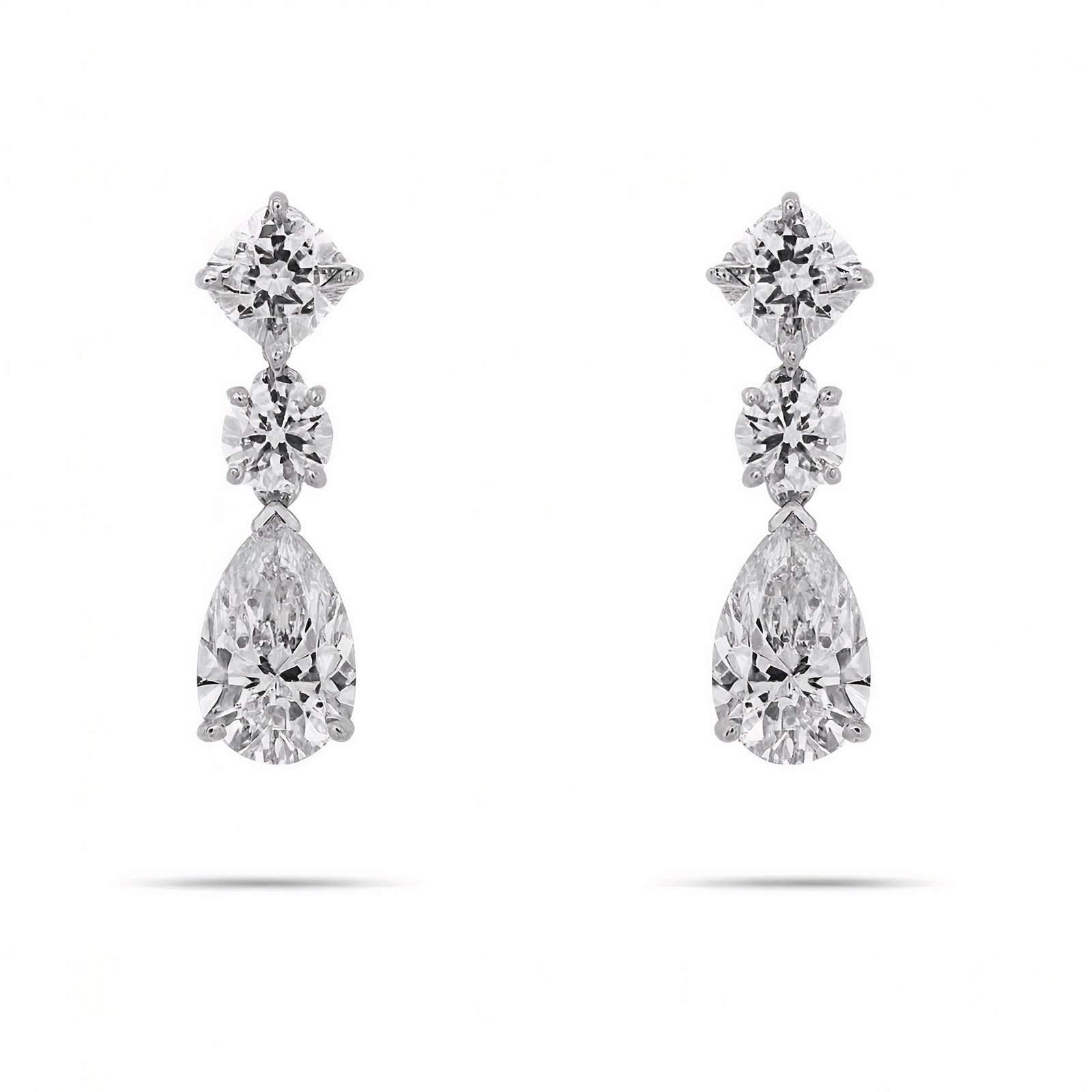 Lab Grown Three Stone Diamond Drop Earring 7.28 Carats D-E VVS2-VS1: Lab Grown Diamond Drop Earrings featuring two Cushions weighing 2.07 CTTW, two Round Brilliants weighing 1.06 CTTW, and two Pear Shape weighing 4.15 CTTW, in 14 Karat White Gold. Color D-E Clarity VS1