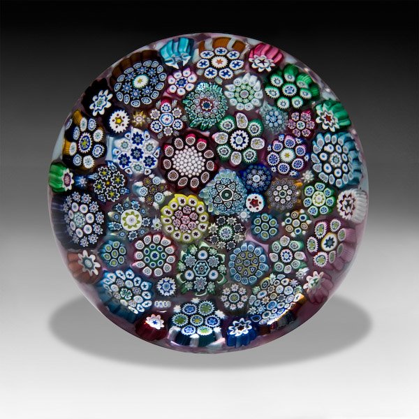 P. McD Glass Studio: P. McD Glass Studio close packed complex millefiori paperweight. A close arrangement of assorted, colorful, large and small complex canes, rests on speckled pink and pale blue ground. "PMcD" signature