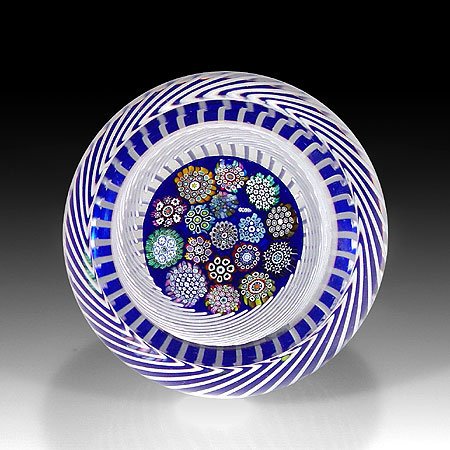 P. McD Glass Studio encased close packed millefior: P. McD Glass Studio encased close packed millefiori in a swirling basket paperweight. Assorted close packed complex canes and a "PMcD" signature cane, rest on cobalt blue ground, within a basket of sp