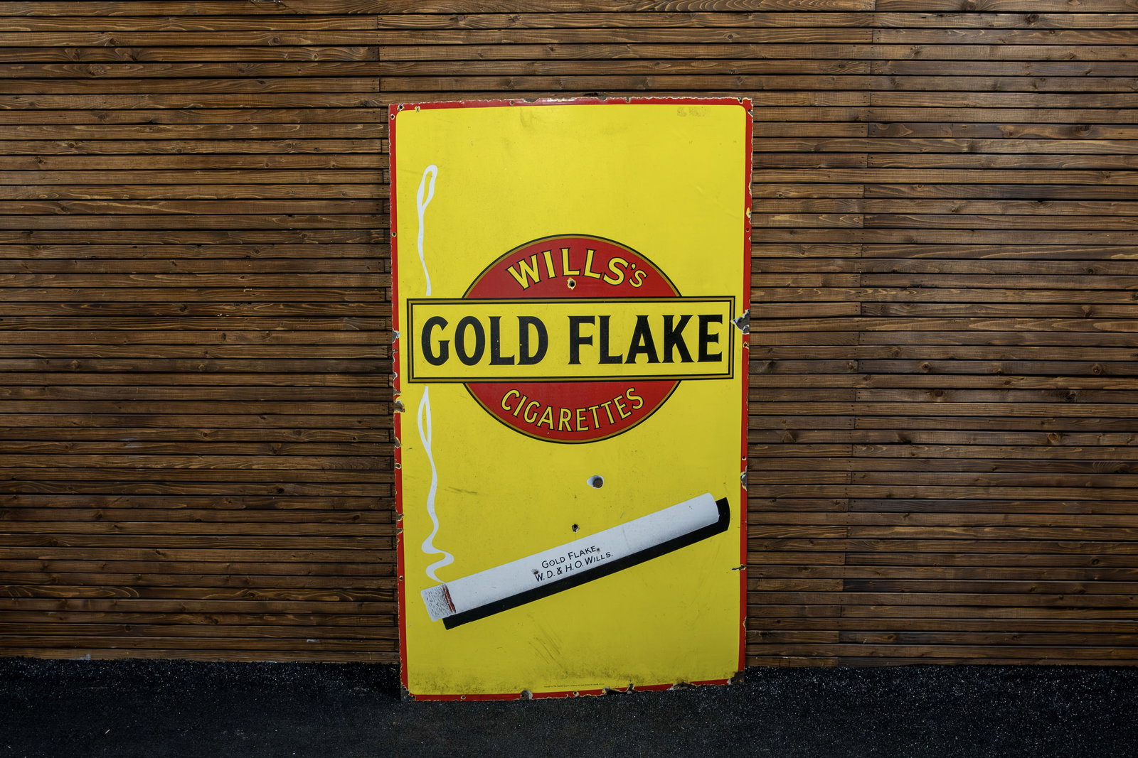 Will's Goldflake Cigarettes Single-Sided Porcelain Sign: 1950s-era original sign presents image of famous India-based cigarette brand from Imperial Tobacco Company, company's logo on yellow field with image of lit cigarette, minor chips on edges. 
