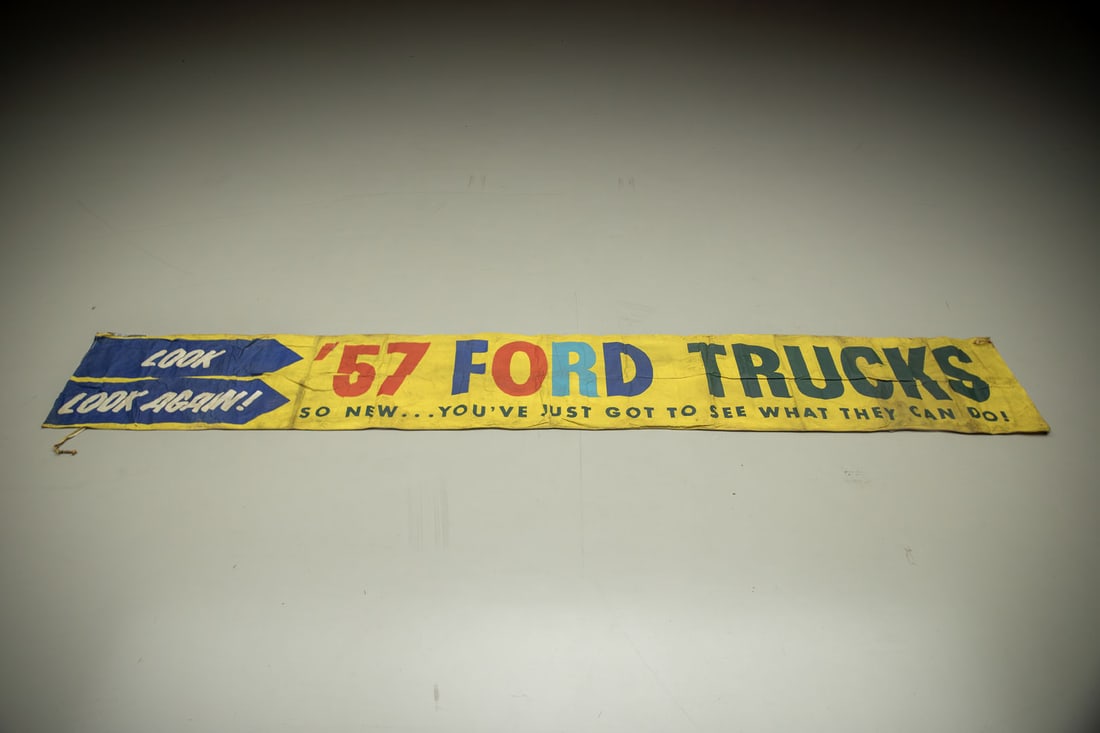 1957 Ford Trucks Original Dealership Advertising Banner: This original colorful banner is over 18' wide and lets customers know, "SO NEW - YOU'VE JUST GOT TO SEE WHAT THEY CAN DO", manila ropes, light soiling, small tears.