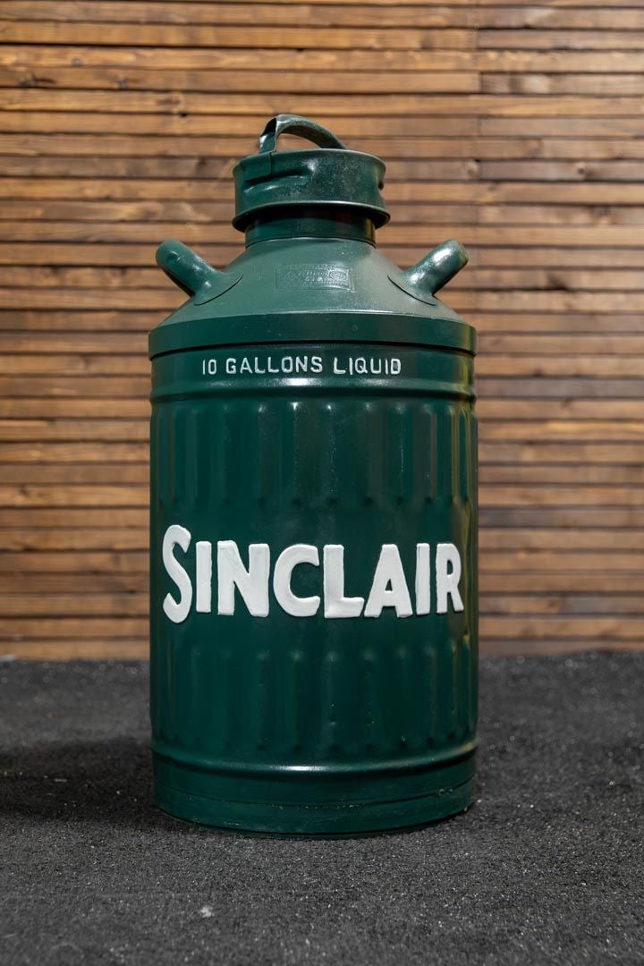 Sinclair-Elisco 10-Gallon Embossed Fuel Can: Vintage container in dark green with embossed lettering in white, dual handle, screw on-off lid secured with chain, minor dents and patina.