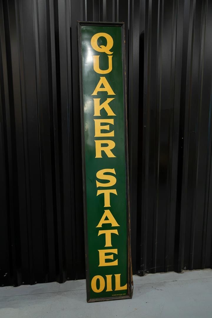 Quaker State Oil Single-Sided Tin Sign: SST with good color and shine, vertical sign with yellowing letters on dark green field. Retains original wood frame with the lower right portion showing a split. Marked Reliance ADV.CO. Rated 9.0