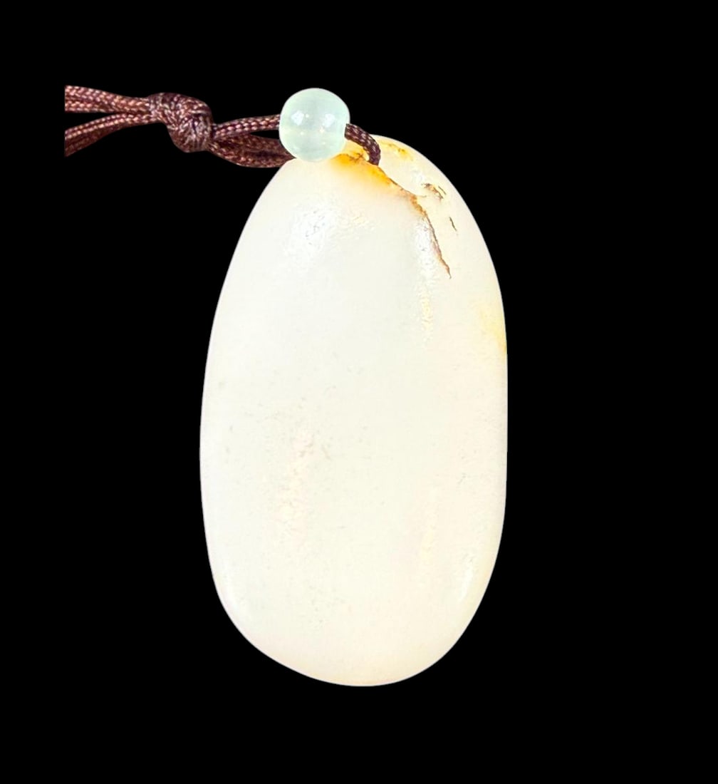 A Very Fine Polished Chinese Hetian Jade Pebble / Toggle of highest quality: Chinese hetian jade pebble / toggle of highest quality and polished. Measures 2.25” long. Provenance: Prolific collector DATO` Dr. Kenneth Chin Kin Lia, MBBS (Mal), FAMM (Mal), FRCP (Glas), FESC