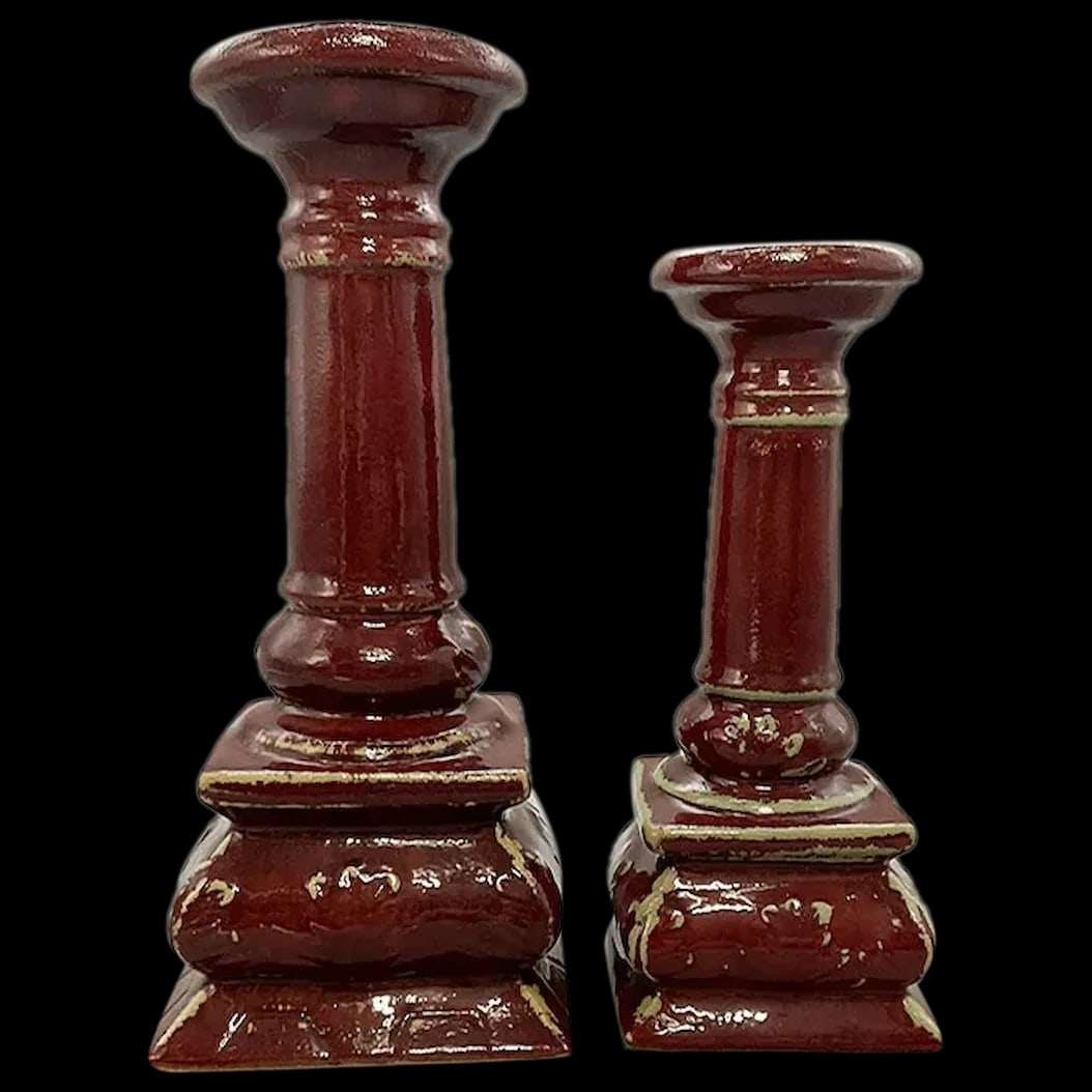 Pair of Candle Sticks: Two Ceramic candle sticks in a red color in different heights with a 4 inch base. They were designed to look vintage.