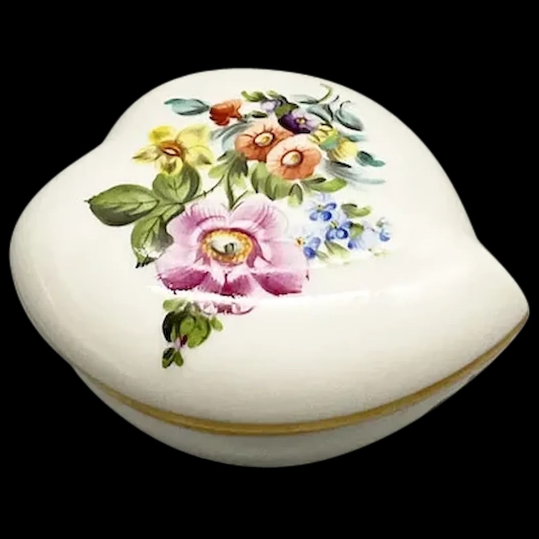 Trinket Box: Herend 1839 Printempts Pattern Heart-shaped bon bon box presents beautifully. A pretty floral bouquet graces this lovely porcelain heart with 24K trim. Once used to contain bon bons they have become