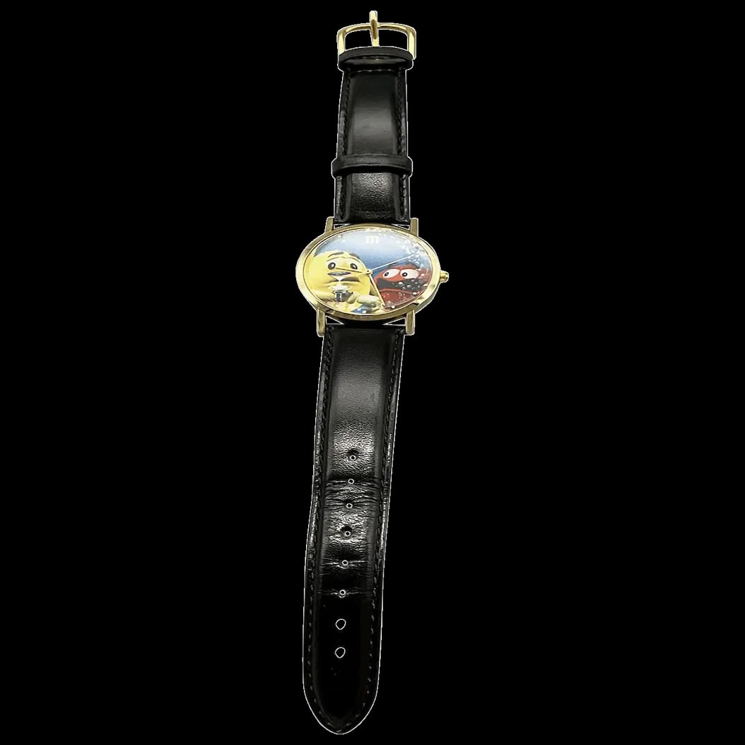 Wrist Watch: M & M Mars Candy Character 1990’s Wrist Watch featuring Yellow Peanut and Red M & M was probably a promotional item. Both the face and back were protected with thin peel-away plastic that