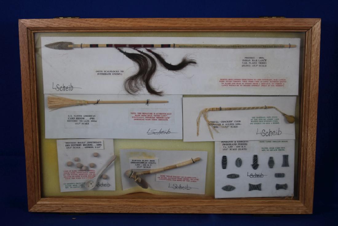 Display Case of L. Scheib Indian Scale Replicas: 6 Pieces including Indian War Lance; Southeast Native American Camp Broom; Skull Cracker Club; Pottery Balls; Hafted Flint Hoe; Pendants & Gorgets; All 1-1/5" scale; Case approx. 12" x 18"