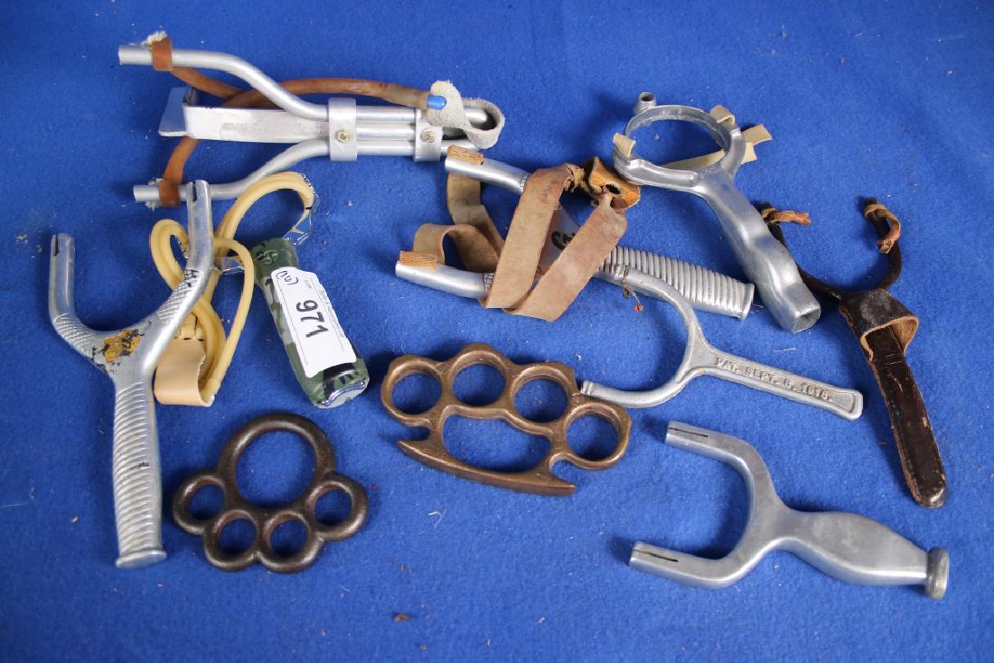 2 Knuckle Dusters & 8 Sling Shots: One brass knuckle duster; Eight aluminum sling shots; One iron knuckle buster