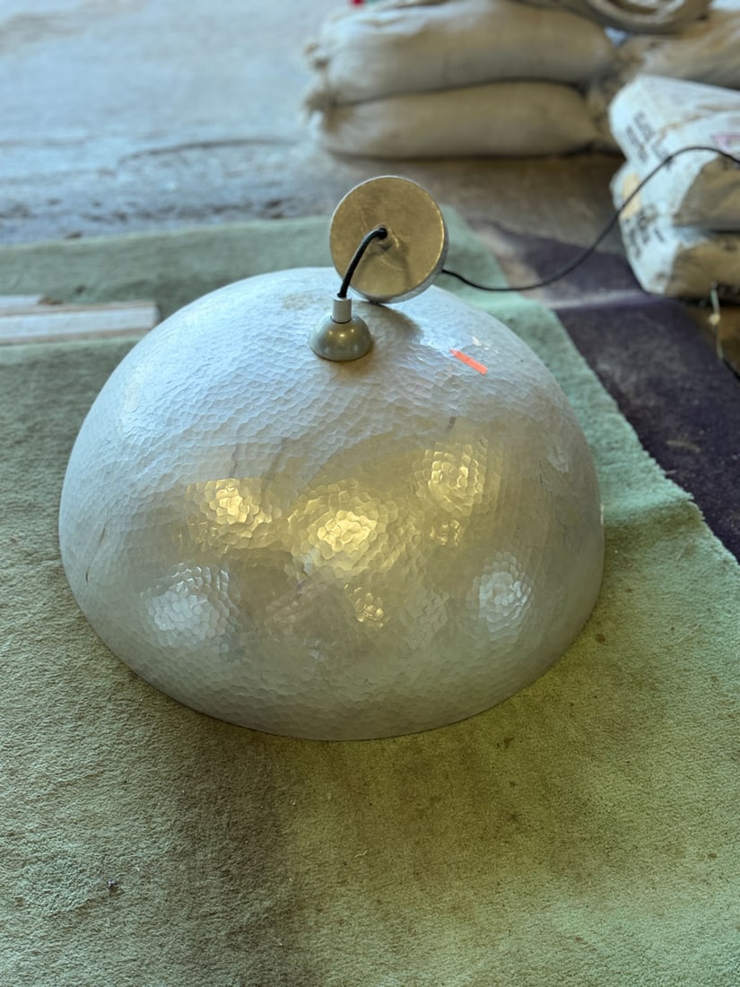 Reclaimed hammered metal pendant light fixture: Reclaimed hammered metal dome shaped pendant light fixture. Measurements: 24" w x 10't x 23" d. Height to ceiling can be adjusted.