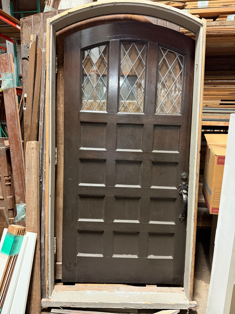 Reclaimed vintage entry door with frame: Reclaimed solid oak arched topped entry door with 12-panels below triple leaded glass windows. Door comes with original arched frame. Door and frame from one of Houston's most prestigious neighborhood