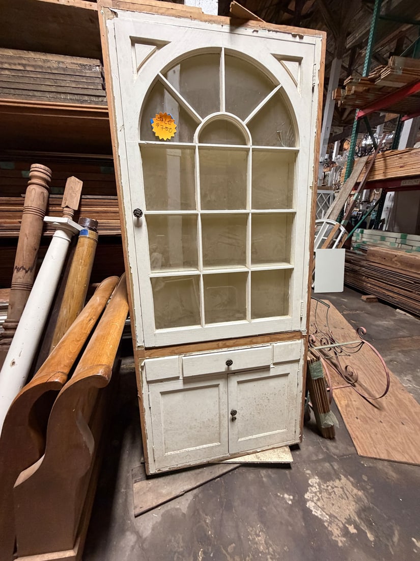 Reclaimed vintage glass fronted corner cabinet: Reclaimed vintage arched topped glass fronted corner cabinet. One pane of glass in front door is cracked and easily replaced. c. 1920'sMeasurements: 53"w x 81 1/2" t x 18"d