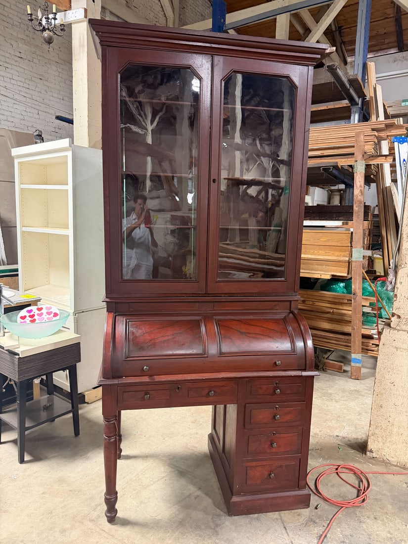 Antique mahogany cylinder roll top desk with upper glass fronted bookcase: Elegant and functional antique cylinder roll top desk featuring rich mahogany finish and classic late 19th century or early 20th century styling. The upper section features a two door glass fronted bo