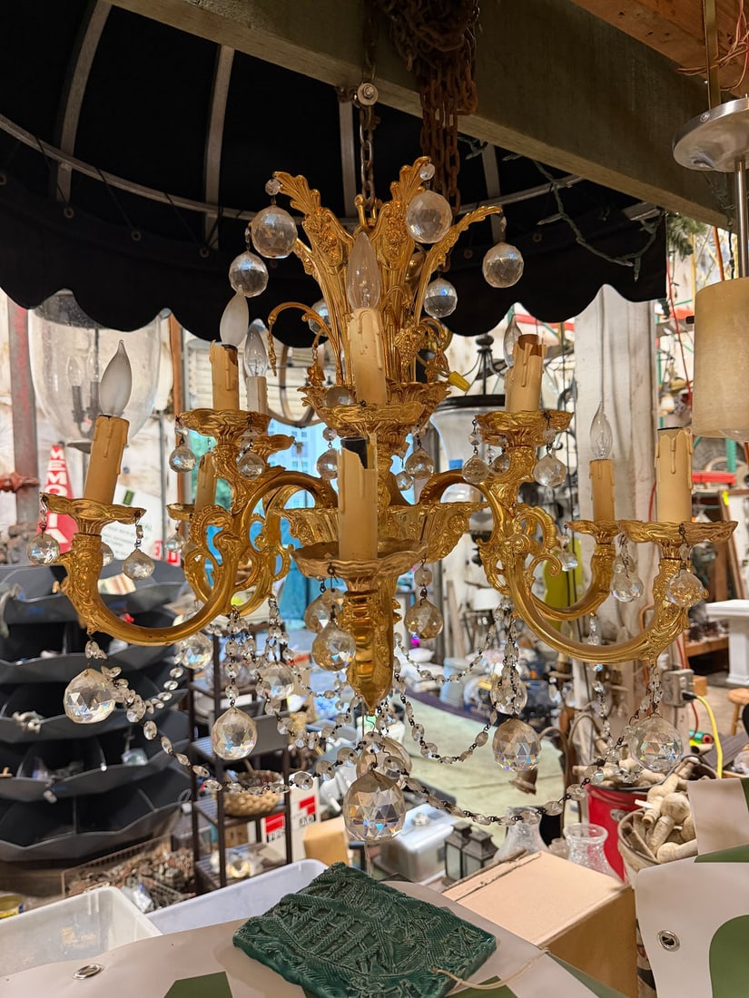 Large Ornate French Gilt Bronze and Crystal Chandelier: Spectacular and highly decorative multi-arm chandelier featuring an elaborate gilt frame with cascading faceted crystal prism and swags.This grand fixture is executed in an opulent French Rococo/Louis