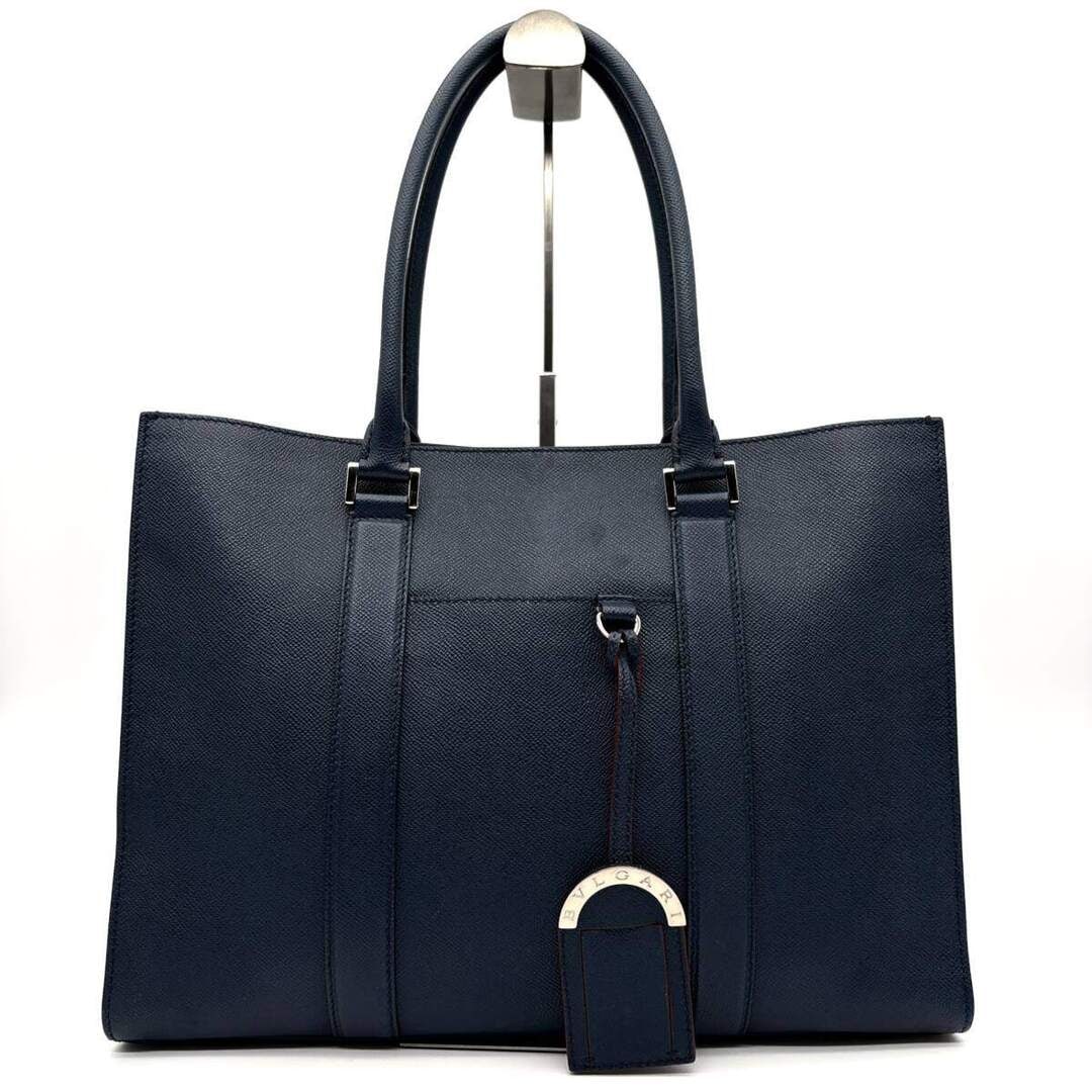 Bvlgari Sac Cabas: BvlgariModel : Cabas cuirMaterial : Cuir de veau grainéSize : 39 x 30 x 9 cmCondition : GoodEra : RecentIncluded : Bag, charm, warranty card