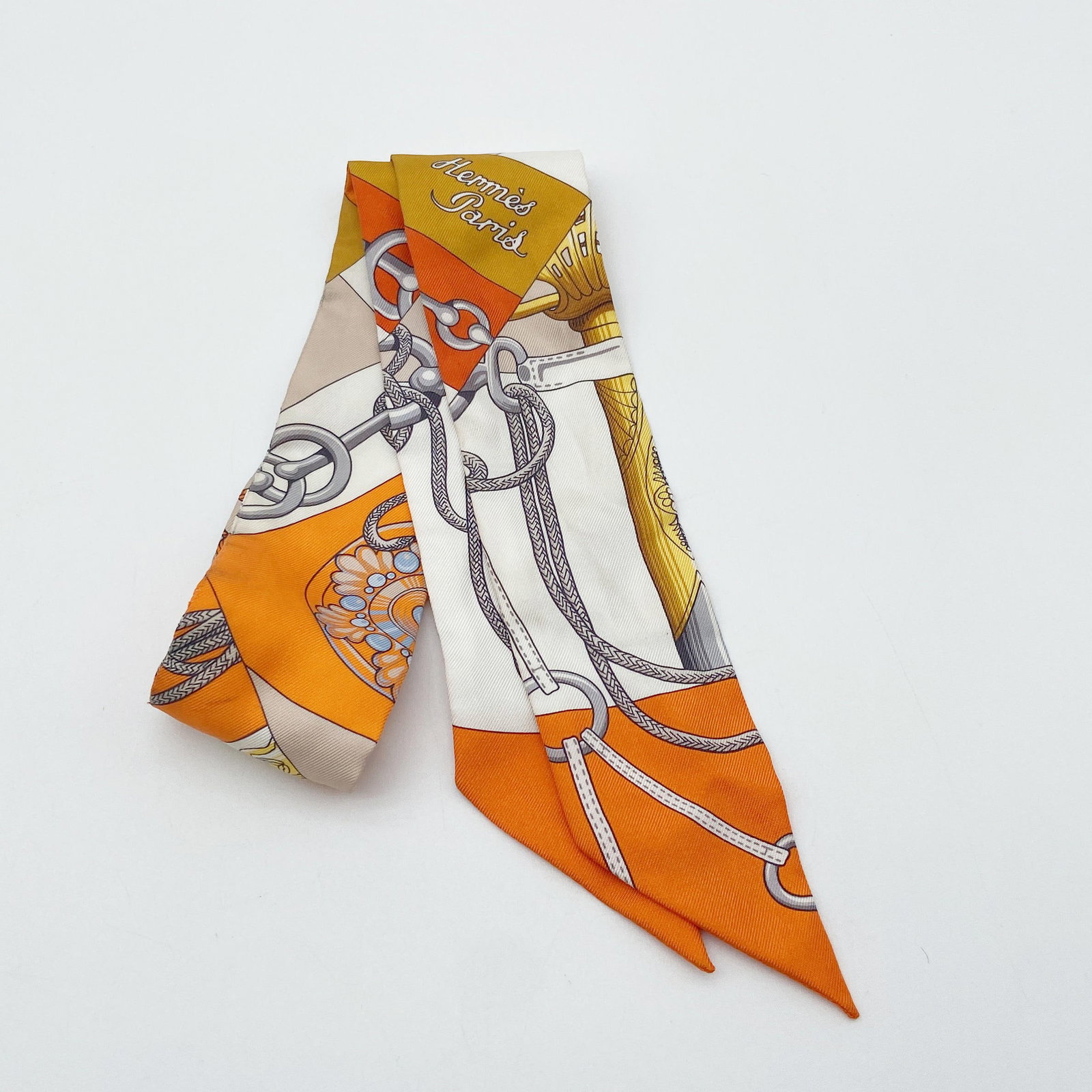 HERMES Twilly Cliquetis MH Orange Blanc Gold Gray: Item Name:Hermes Twilly Cliquetis MH Orange Blanc Gold GrayBrand:HermesModel No.:07942962Sizs:86cm*5cmWeight:N/AMaterial:SilkAccessories:BoxCondition New; Perfect condition