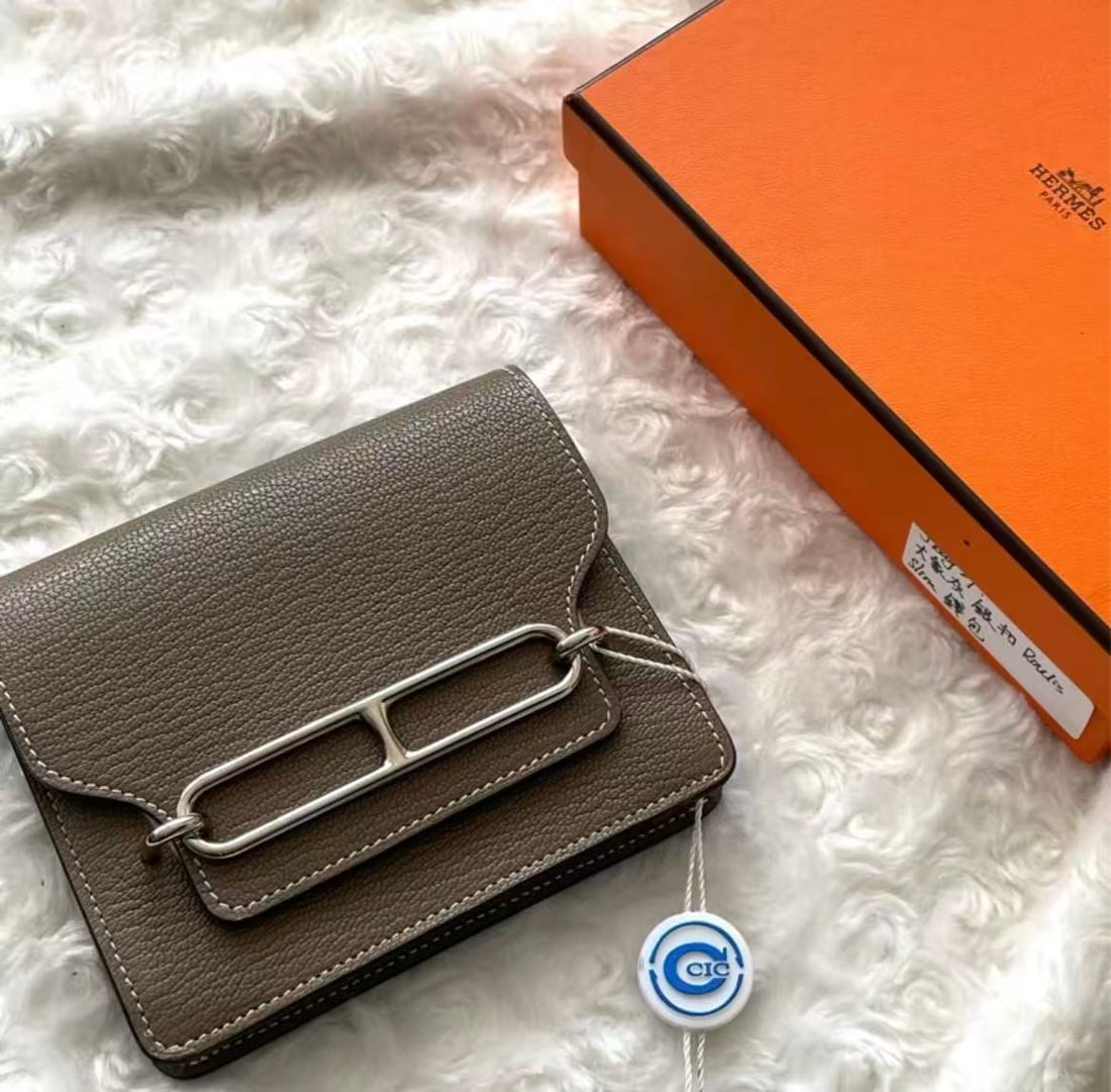 HERMES Etoupe Roulis Slim Wallet: Item Name: Hermes Roulis Slim Etoupe Silver Buckle Wallet Brand: HERMES Model No.: U AM 007 UM Sizs:12.5cm*10.5cm*2cm Color:Etoupe Material:Sheepskin Leather Accessories:Card/Dust Bag/Box