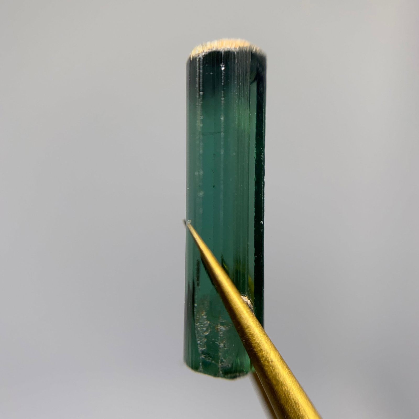 Rare Rough Green Tourmaline Mineral Specimen: A naturally terminated 2.45ct rough green tourmaline crystal exhibiting classic striations and strong verdant color. Naturally terminated green tourmalines with strong color are prized and rare geolog