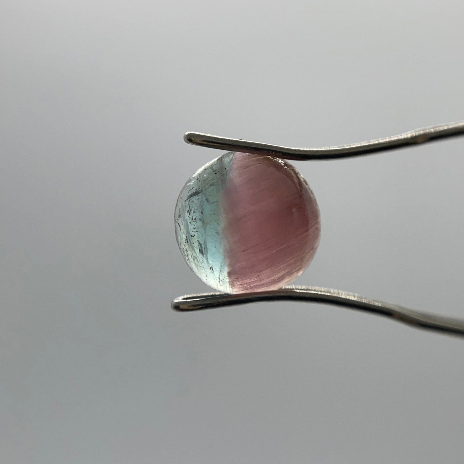 Rare Natural Bi-Color Tourmaline Cabochon: A distinct 1.31ct cabochon-cut tourmaline clearly exhibiting two distinct, natural color zones in one continuous stone. Distinctly separated dual color zones in a single continuous cabochon are an inc