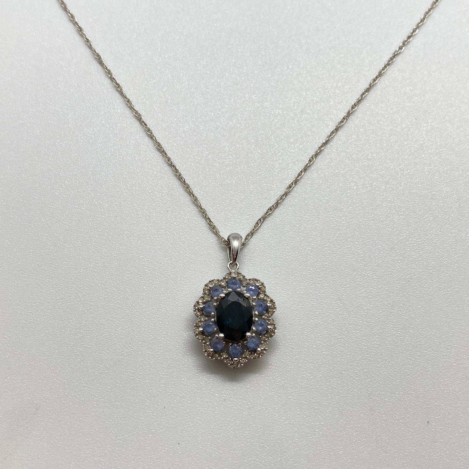 Heirloom 14K White Gold Sapphire & Diamond Pendant Necklace: An elegant 3.31g 14K white gold necklace featuring a stunning natural sapphire and diamond halo pendant on a fine chain. Stunning natural sapphire and diamond halo pendants in this condition are rare 