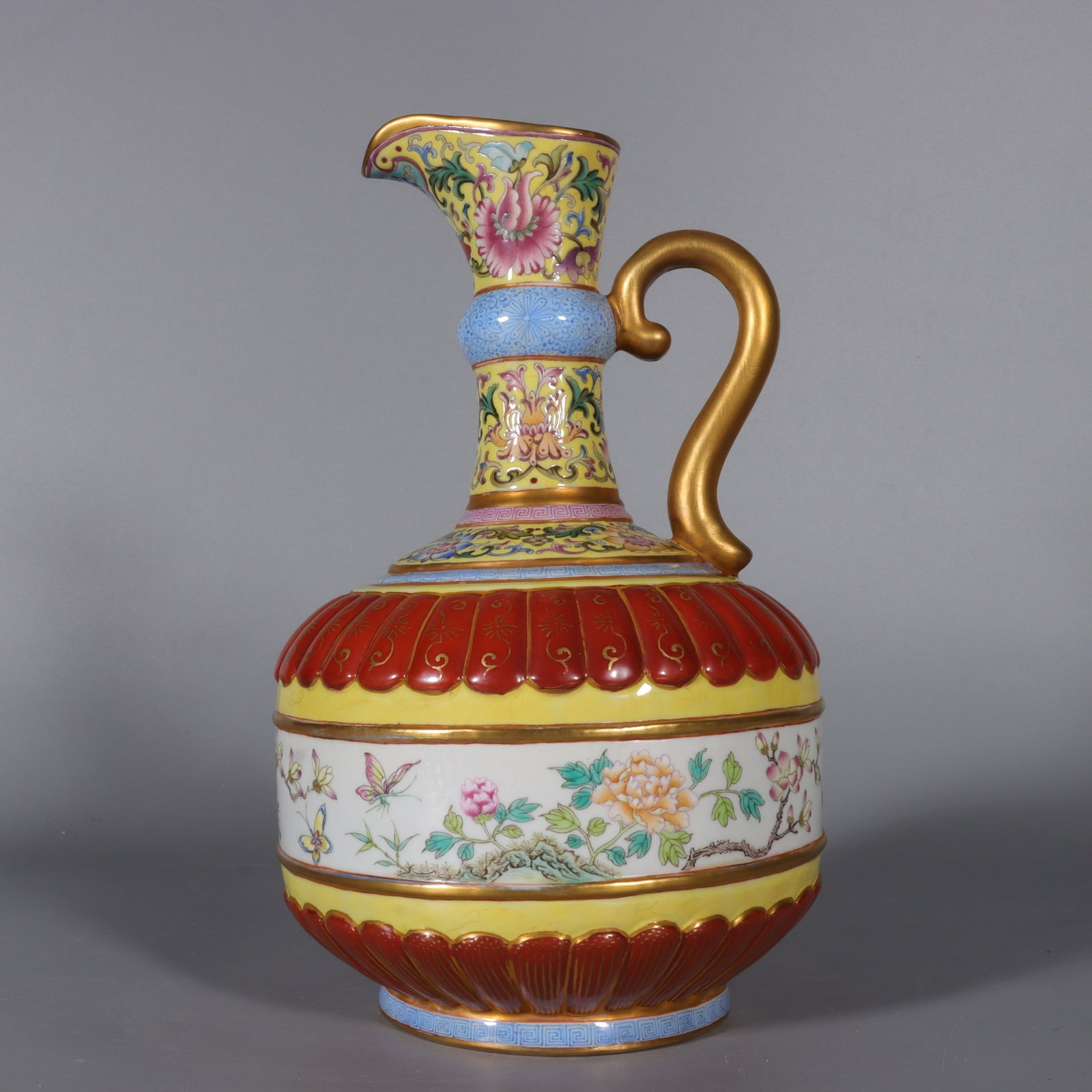 A Qing Dynasty enamel colorful yellow ground carved entwined lotus alum red with gold painted floral: The Qing Dynasty's enamel is carved on a yellow ground, entwined lotus alum, red gold-painted floral pattern flower pouring pot Size:H:23cm Calibre:6.5cm Belly diameter:13.5cm Bottom:9cm (The