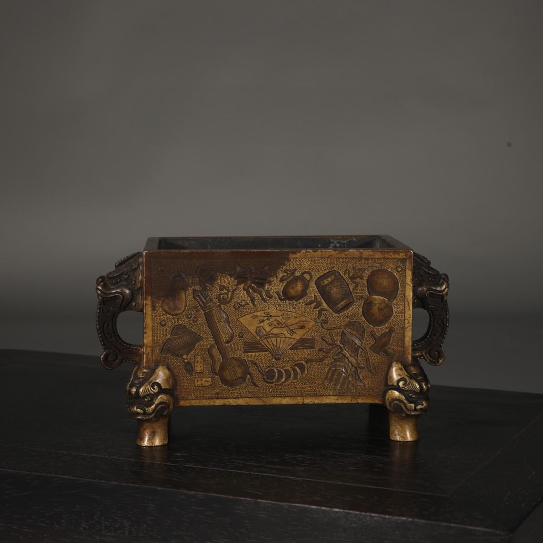A Ming Dynasty finely cast copper tire miscellaneous treasure pattern dragon head ear manger furnace: The Ming Dynasty's precisely cast copper tire miscellaneous treasure pattern dragon head ear manger furnace Size:H:9cm Calibre:7.6x12.5cm Ear distance:17.6cm W:2kg (The Dimensions Of All Batches Are
