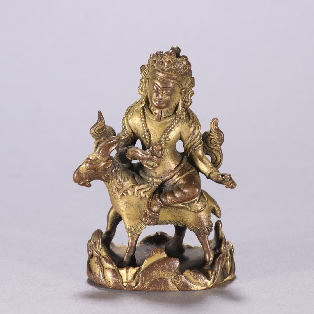 A finely crafted gilt bronze statue of a guardian deity riding a sheep (1 of 9)