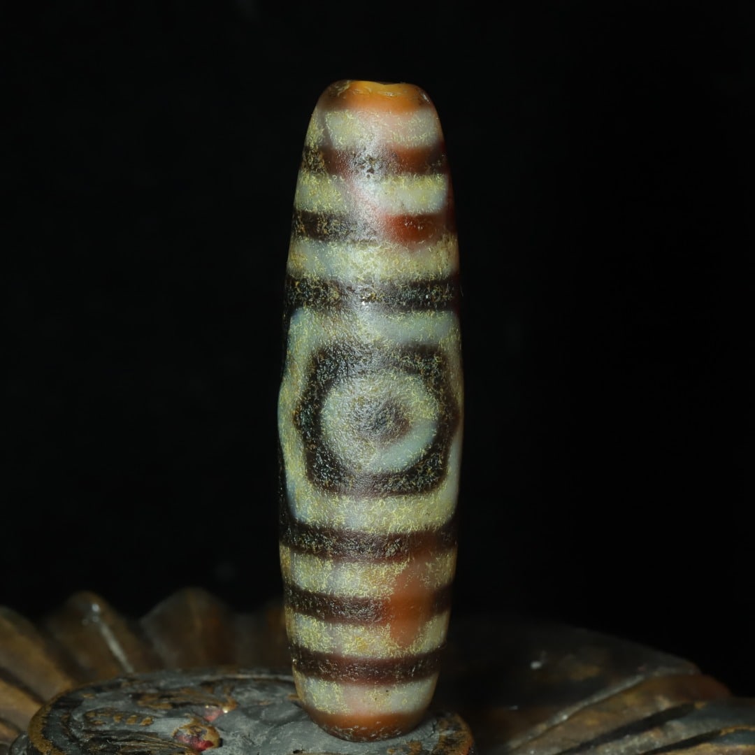 A beautiful three-eyed cinnabar Dzi bead: Exquisite three-eyed cinnabar Dzi beads Size:46x13mm W: 0.012 kg Size:46x13mm W: 0.012 kg (The Dimensions Of All Batches Are Manually Measured.If You Need More Detailed Information, Please Contact