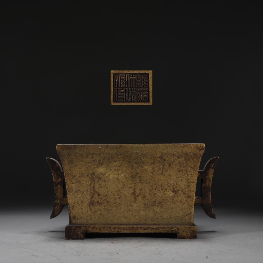 A Qing Dynasty finely cast bronze-bodied square halberd-handled burner: A Qing Dynasty finely cast bronze-bodied square halberd-handled stove Size: H: 11cm Calibre 17.2x15.1cm Ear distance: 22.3cm W: 3.7 kg Size: H: 11cm Calibre 17.2x15.1cm Ear distance: 22.3cm W: 3.7 kg 