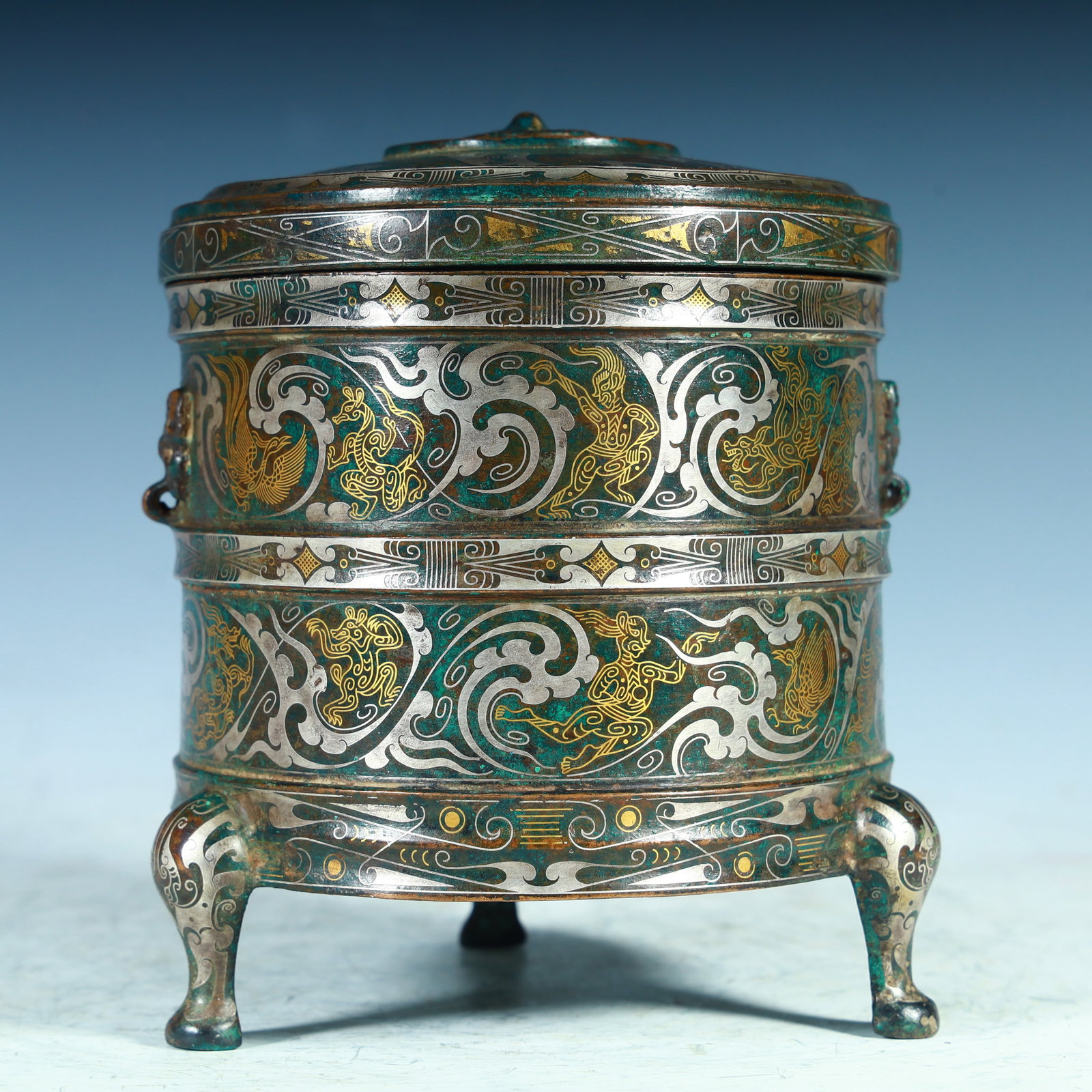 A Han dynasty bronze gold and silver beast pattern round three-legged lid box: Han dynasty bronze treasury gold and silver beast-patterned round three-legged lid box SIZE: 13cm H:16cm W:1630g SIZE: 13cm H:16cm W:1630g (The Dimensions Of All Batches Are Manually Measured.If You