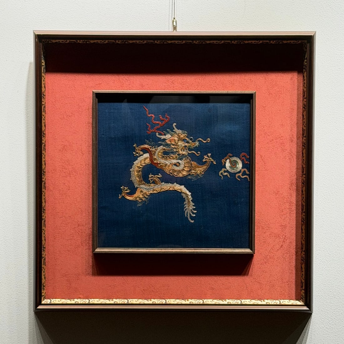 A Qing Dynasty piece featuring a gold-plated embroidered golden dragon playing with a pearl (1 of 4)