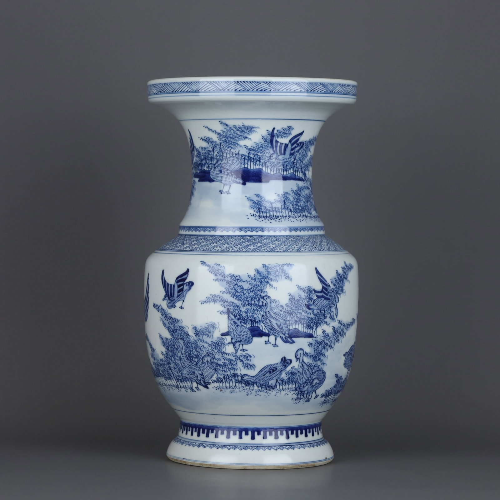 A Qing Dynasty Kangxi period blue and white bamboo bird-patterned pan-mouth vase: A blue-and-white bamboo bird-patterned bamboo bowl with a rim made during the Kangxi period of the Qing Dynasty Size: H: 33cm Calibre: 18.3cm Belly diameter: 19cm Size: H: 33cm Calibre: 18.3cm Belly d