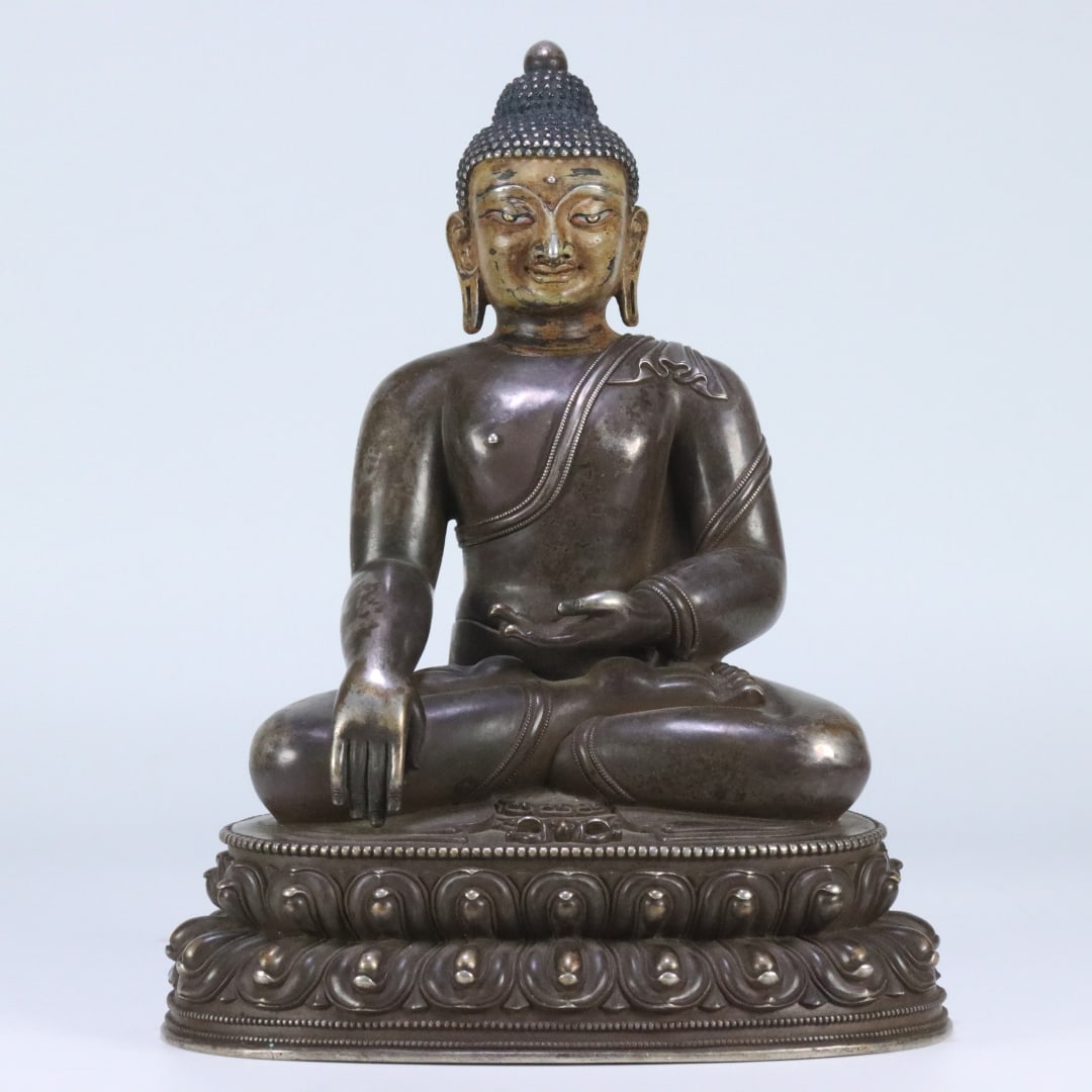 A Qing Dynasty bronze, gilded, and silver seated statue of Shakyamuni Buddha: A seated statue of Shakyamuni Buddha from the Qing Dynasty, gilded and silver Size:26x21x15.6cm W:3.775 kg Size:26x21x15.6cm W:3.775 kg (The Dimensions Of All Batches Are Manually Measured.If You Need